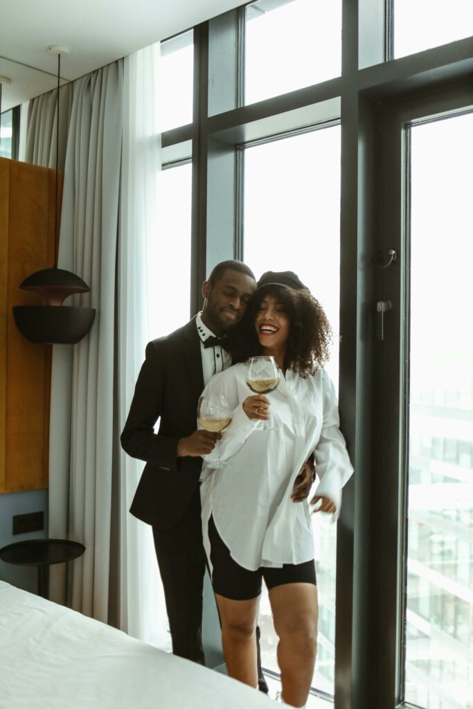 Man Holding Wine Glass Standing Behind a Woman