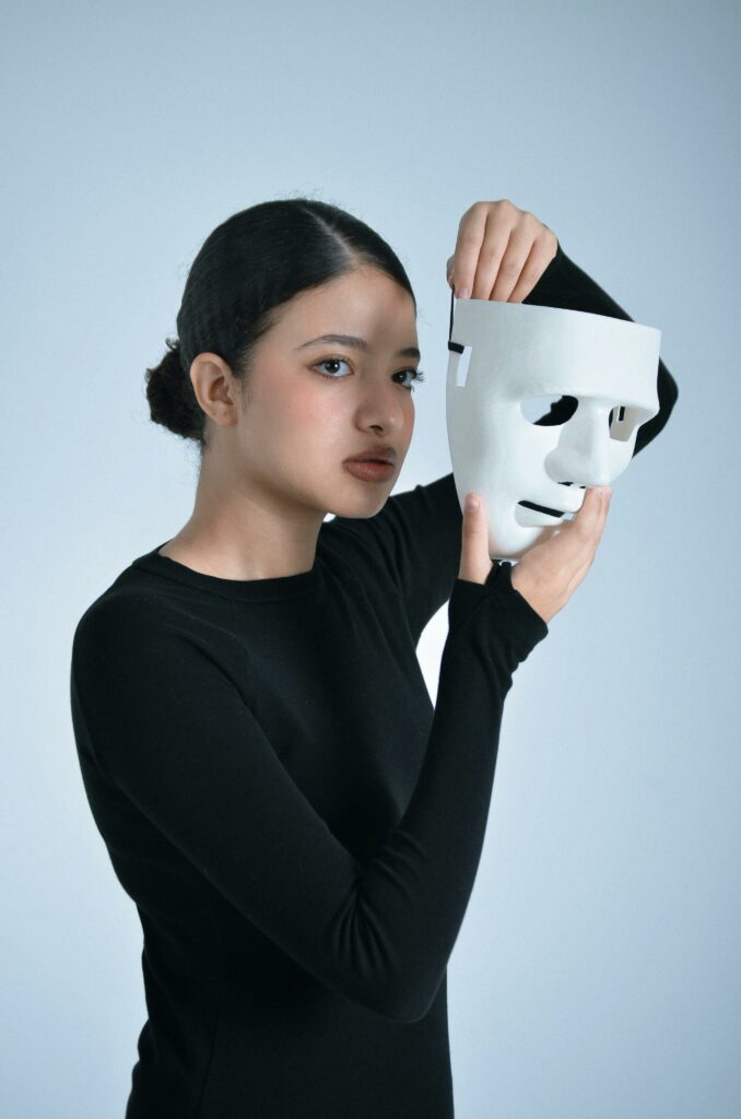 Woman Holding White Mask in Reflective Pose